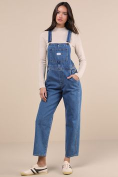 The Levi's Vintage Medium Blue Overalls are a tried and true staple that we know you're going to love! Sturdy denim (in Levi's Foolish Love wash) shapes these classic overalls that have a front bib with a patch pocket (with a logo tag) and adjustable straps that form into a modified racerback. A seamed waist tops relaxed fit straight leg bottoms with two front pockets and two back pockets. Branded button closures at the hips. Red logo tag at back. Fit: This garment fits true to size. Length: Flo Jean Jumpsuit, Blue Overalls, Denim Jumper, Comfortable Room, Red Logo, Logo Tag, Jeans Jumpsuit, Denim Overalls, Tried And True