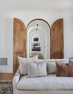 a white couch sitting in front of two wooden doors