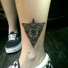 a woman's leg with an all seeing eye tattoo on it