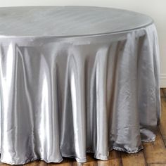 the table is covered with silver cloths and sits in front of a white wall