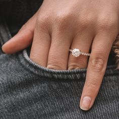 a close up of a person's hand with a diamond ring on their finger