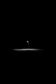 a black and white photo of a light in the dark