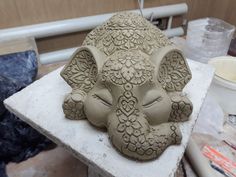 a clay elephant head sitting on top of a table