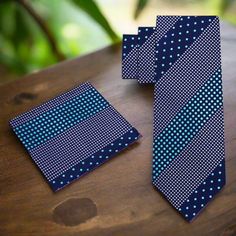 This silk necktie, featuring a sophisticated dark blue background adorned with light blue polka dots, is a perfect blend of classic and playful styles. The contrasting colors and charming pattern make it a versatile accessory for various occasions, adding a touch of elegance and fun to your attire. Dress Shirts: White Dress Shirt: A white dress shirt offers a clean and classic look, making the dark blue and light blue polka dots stand out beautifully, perfect for both formal and semi-formal sett Dapper Blue Tie Suitable For Gift, Dapper Blue Tie As Gift, Dapper Blue Tie For Gift, Blue Tie With Pocket Square As Gift, Dapper Blue Standard Tie, Classic Blue Business Ties, Elegant Polka Dot Ties, Blue Silk Neckwear With Ties, Blue Semi-formal Necktie