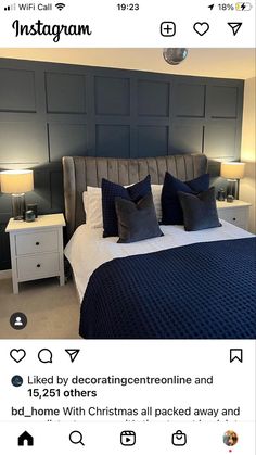 the bed is made up with blue and white pillows on it, along with two nightstands