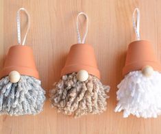 three different types of mop holders on a wooden surface with white and gray yarn