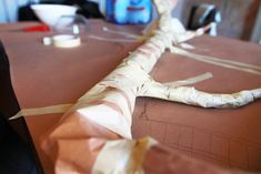 a long piece of paper is wrapped in brown and white tape on top of a table