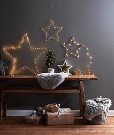 a wooden bench with christmas decorations and lights on the wall above it, along with other presents