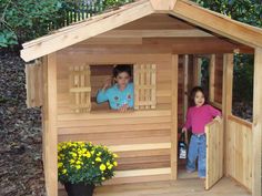 two young children standing in a wooden play house