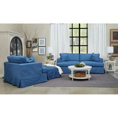 a living room with blue couches and white coffee table in front of a window