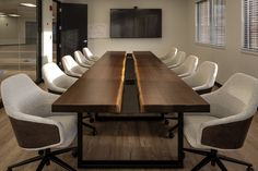 an empty conference room with white chairs and a wooden table