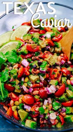 a glass bowl filled with mexican salad and lime wedges