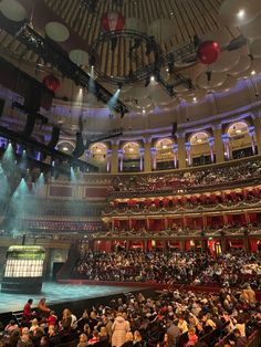 an auditorium filled with lots of people and lights