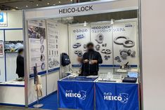 a man standing in front of a booth at a trade show with heco - lock