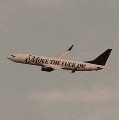 an airplane with the words move the flock on it flies through the sky in preparation for takeoff