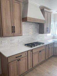 a kitchen with wooden cabinets and white counter tops