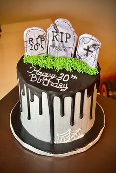 a birthday cake decorated with tombstones and green grass for the top layer is black and white