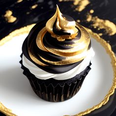 a black and gold cupcake sitting on top of a white plate