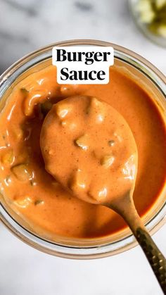 a glass jar filled with sauce on top of a table