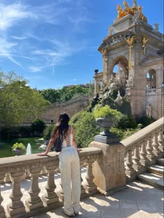 a woman is standing on a balcony looking at the water