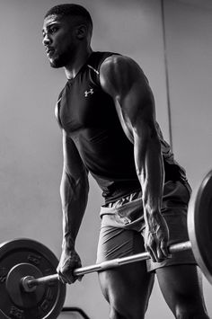 a man is holding a barbell in the gym