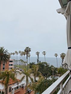 an open balcony with palm trees and the ocean in the background