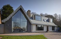 a modern house with large glass windows on the roof