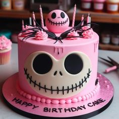 a pink birthday cake with a skull on top