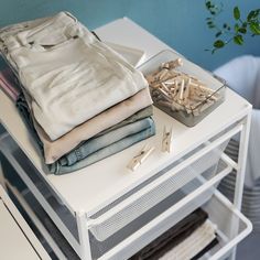 folded clothes are sitting on top of a white table