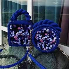 two blue purses sitting on top of a glass table