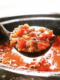 a spoon full of chili and meat soup