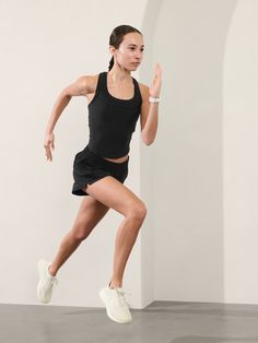 a woman in black shirt and skirt running