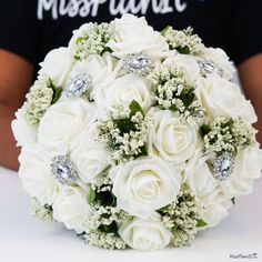 a bridal bouquet with white roses and baby's breath