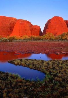 the red rock formations are reflected in water