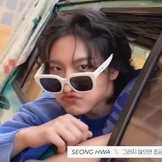 a young man wearing sunglasses sitting in a car