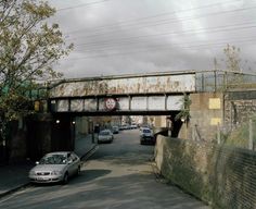 cars are driving under an overpass on a road in the middle of a city