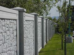 a row of stone walls next to a grassy field