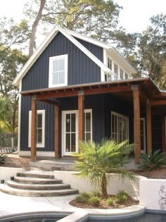 a house with a pool in front of it and steps leading up to the porch