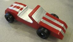 a wooden toy car with white and red stripes