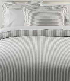 a bed with grey and white striped sheets