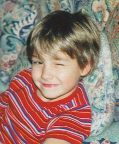 a young boy sitting on top of a couch