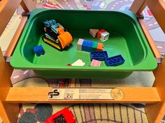 a toy train set sitting on top of a wooden table next to a green tray