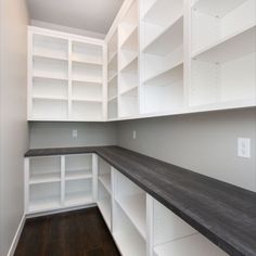 an empty room with white shelving and wood floors