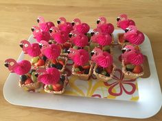 there are many cupcakes with pink flamingos on them sitting on a plate