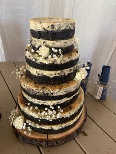 a wedding cake is stacked on top of a tree stump with flowers in the center