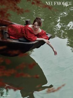 a woman in a red dress is sitting on a boat