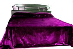 a bed with purple bedspread and pillows