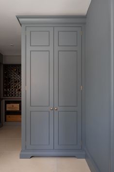 an empty room with blue cupboards and wine rack