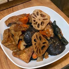 a white plate topped with food on top of a wooden table