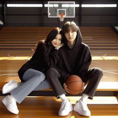 two people sitting on a bench with a basketball